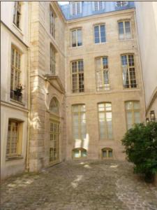 een groot bakstenen gebouw met veel ramen bij Charming Cosy Triplex in Trendy Marais in Parijs