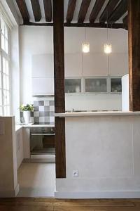 a kitchen with white cabinets and a stove top oven at Charming Cosy Triplex in Trendy Marais in Paris