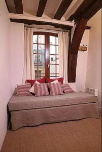 een groot bed in een kamer met een raam bij Charming Cosy Triplex in Trendy Marais in Parijs