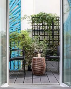 a patio with two chairs and a table with a plant at Hotel Les Bains Paris in Paris
