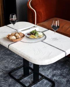 فندق لي بان باريس في باريس: طاولة مع طبق من الطعام وكأسين من النبيذ