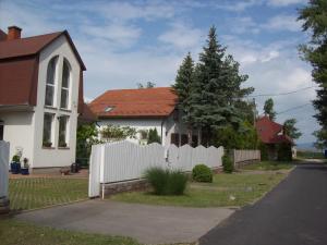 uma cerca branca em frente a uma casa branca em Perge Üdülövilla em Balatonszárszó