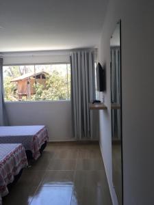 a hotel room with two beds and a window at Pousada Belo Recanto - Pipa in Pipa