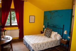 1 dormitorio con 1 cama con paredes amarillas y azules en Casa Rural y Spa El Huerto del Abuelo, en Almiruete