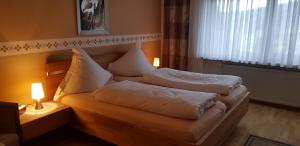 a bedroom with two beds with pillows and a window at Ferienwohnungen Grill in Schönberg