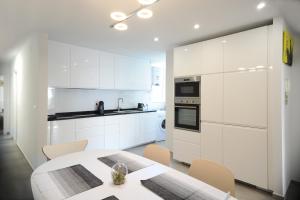 a kitchen with white cabinets and a table and chairs at Sunset in Santa Pola
