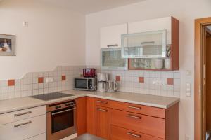 a kitchen with a stove and a microwave at Appartementhaus Steirergasse by Schladming-Appartements in Schladming +30 photos