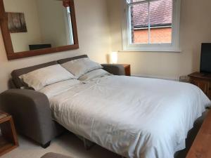 un grande letto in una camera da letto con specchio di Hartington House a Woodhall Spa