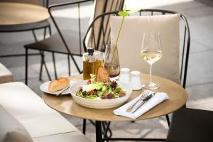 a table with a bowl of salad and a plate of food at The Guesthouse Vienna in Vienna