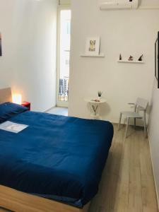 una camera con un letto blu e un tavolo di Dimora san giovanni maggiore a Napoli