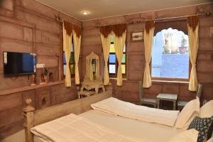Un televizor și/sau centru de divertisment la Dev Kothi - Boutique Heritage Stay