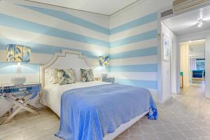 a bedroom with blue and white striped walls and a bed at THE LAKERS Boutique Apartment in Quinta do Lago +32 photos
