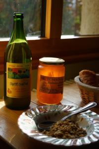 a table with a bottle of wine and a plate of food at Auberge de la Perdrix in Hauterive-la-Fresse