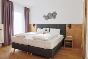 a bedroom with a large bed with white sheets at Seelos - Alpine Easy Stay - Bed & Breakfast in Mieming