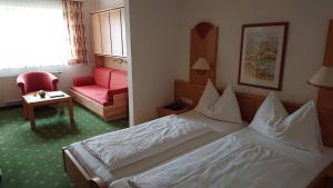 Habitación de hotel con cama y silla en Hotel Alpenrose, en Tauplitzalm