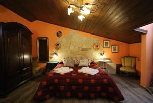 a bedroom with a large bed with orange walls at Kimera in Piazza Armerina