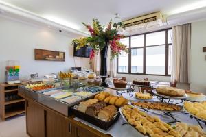un buffet con muchos tipos diferentes de comida en una mesa en Tri Hotel Executive Criciúma, en Criciúma