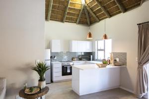 Una cocina con gabinetes blancos y encimera. en Maya Manor, en Hoedspruit