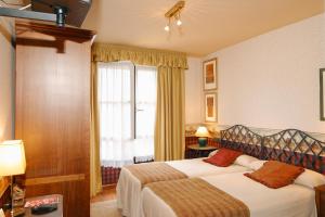 a hotel room with two beds and a window at Hotel Avenida Real in Villaviciosa