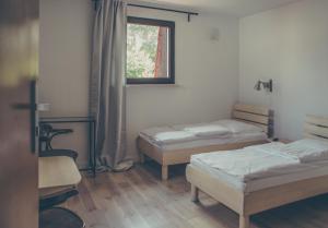 a room with two beds and a window at Hotel Dwa Księżyce in Toruń