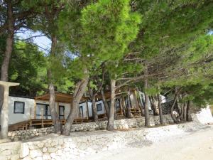 a home on the beach with trees in the foreground at Kamp Dole - Navores in Živogošće