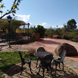 vier stoelen en een tafel in een park bij Casa Realidad y Ensueño in Villa de Leyva
