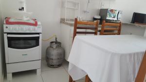 cocina con fogones y mesa con mantel. en Condomínio Mont Hebron - Apto 3A, en Porto Seguro