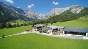 an aerial view of a house in a field with mountains at Auerbauer in Maria Alm am Steinernen Meer