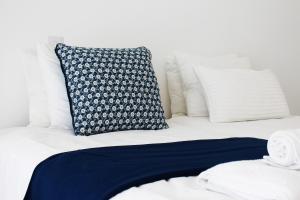 a bed with a blue and white pillow on it at Olosuites in Limassol