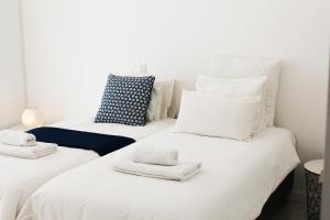 two twin beds with towels on them in a room at Olosuites in Limassol