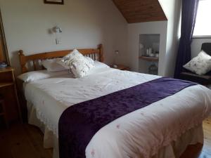 ein Schlafzimmer mit einem großen Bett mit weißer Bettwäsche und Kissen in der Unterkunft Melrose B&B in Clonakilty