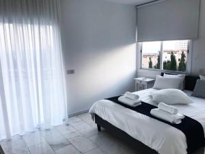 a bedroom with a large bed with towels on it at Olosuites in Limassol