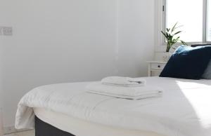 a white bed with towels on top of it at Olosuites in Limassol