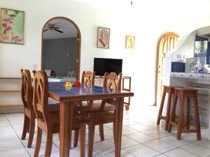 a dining room with a wooden table and chairs at La Perlita in Jacó