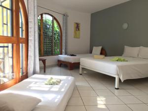 a room with two beds and a window at La Perlita in Jacó