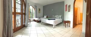 a bedroom with a bed and a room with a window at La Perlita in Jacó