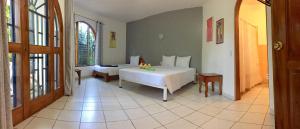 a bedroom with a bed and a room with a window at La Perlita in Jacó