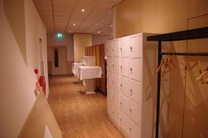 a room with a row of white cabinets and a hallway at Hostel 45 in Purmerend
