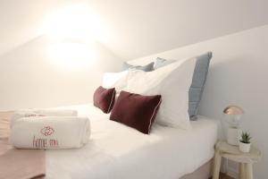 a white bed with a bunch of pillows on it at HM - OPorto City View in Porto