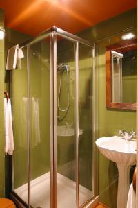 La salle de bains est pourvue d'une douche et d'un lavabo. dans l'établissement Hotel Avenida Real, à Villaviciosa