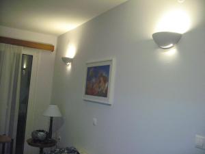 two lights on a wall with a painting on it at Muses Studios Sami in Sami