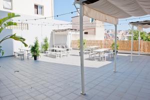 een patio met tafels en stoelen en een parasol bij Gin o clock Apartment 3A in Lissabon