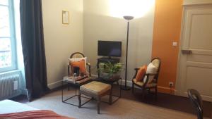 Habitación con 2 sillas, TV y mesa. en Chambre d'hotes Les Rives de la Tronne en Mer