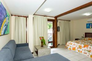 sala de estar con sofá y cama en Blue Marlin Apartments, en Natal