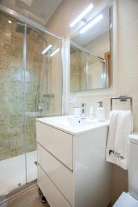 een witte badkamer met een wastafel en een douche bij Lukanda Mariana in Sevilla