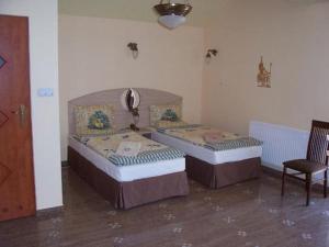 2 camas sentadas en una habitación con silla en Hotel Faraon, en Kielce