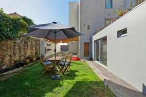 un patio con tavolo, sedie e ombrellone di 12Onze a Espinho