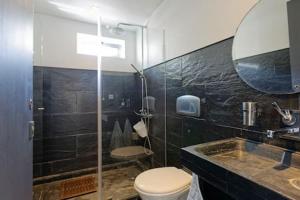 un bagno con un water, un lavandino e uno specchio di 12Onze a Espinho Altre 24 foto