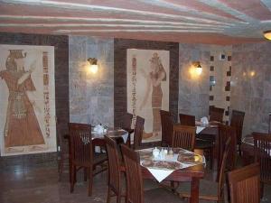 キェルツェにあるHotel Faraonの壁にテーブルと椅子とポスターが掛けられたレストラン