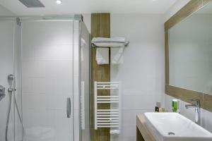 
a bathroom with a shower, sink, and toilet at Best Western Premier Santa Maria in LʼÎle-Rousse
